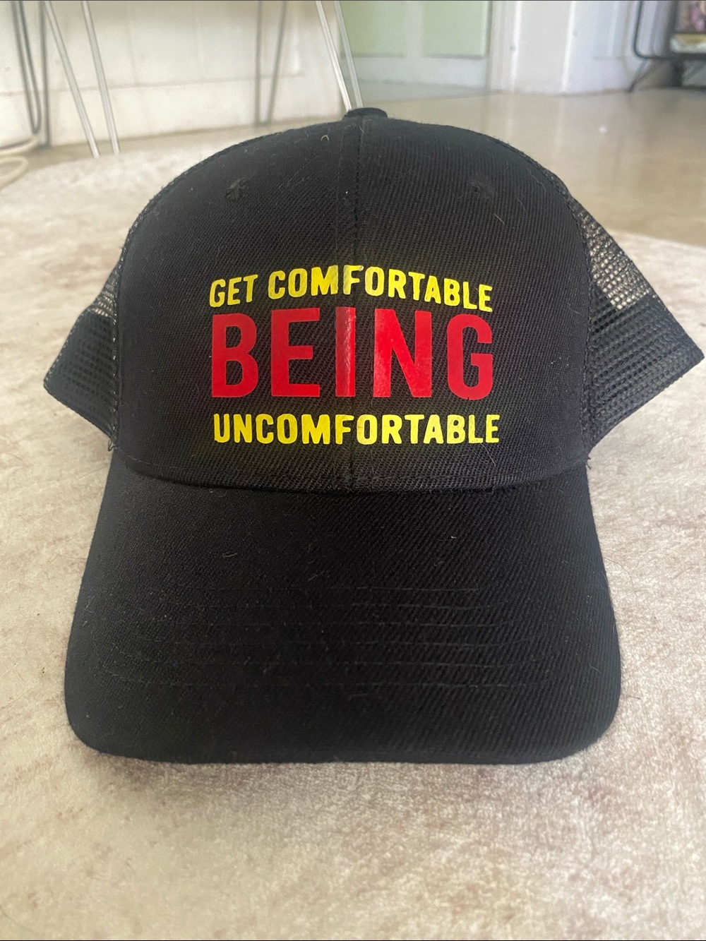 Black Trucker Hat with 'Get Comfortable Being Uncomfortable' Text